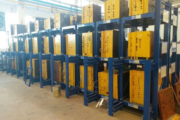 A worker easily accessing a heavy mold from a drawer-style mold rack.