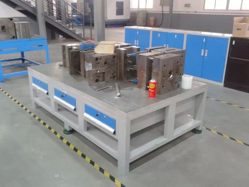 A heavy-duty mold table supporting a large industrial mold in a clean workshop.