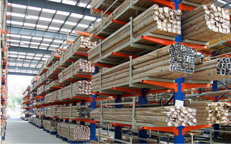 A well-organized warehouse with cantilever racking storing long metal pipes.
