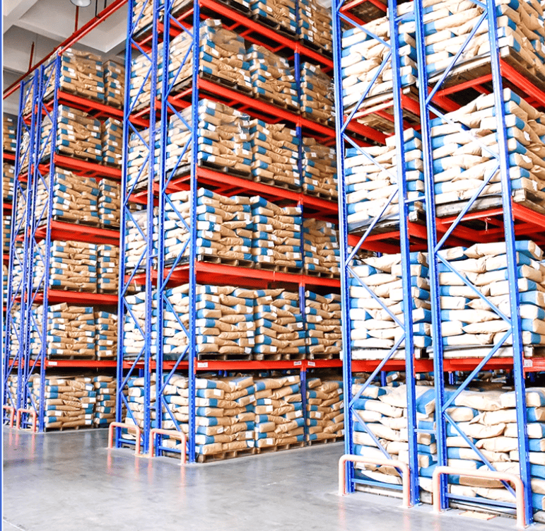 A cluttered factory warehouse floor with items piled up